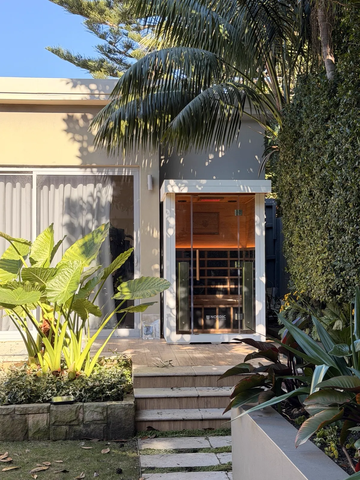 Nordic sauna with timber deck and tropical garden by BuiltByAJ, Sydney